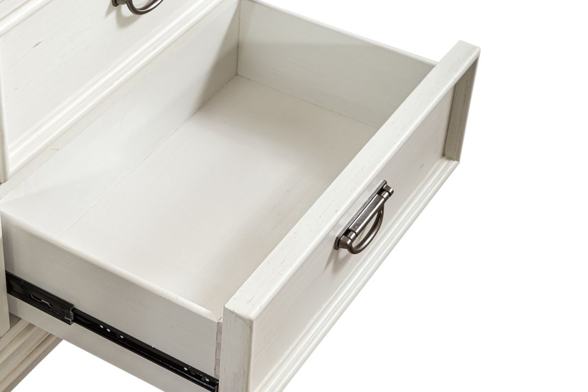 A close up image of a white wood drawer within a chest of drawers