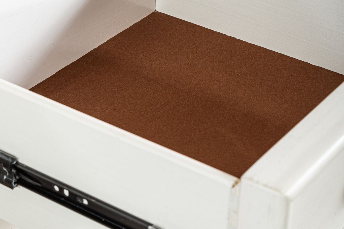 Close up image of the top drawer of a chest showing its lined with felt for storage of delicate items
